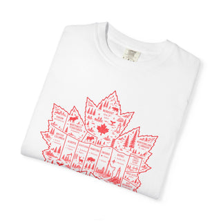 A folded white crewneck t-shirt featuring a red graphic of a Canadian maple leaf filled with illustrations of national parks, wildlife, and geographical landmarks.