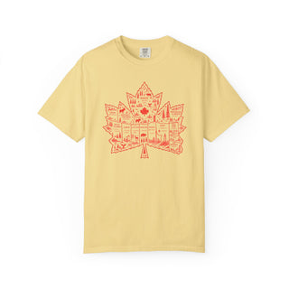 A pale yellow short-sleeve t-shirt with a red graphic of a Canadian maple leaf filled with illustrations of national landmarks, shown on a plain white background.